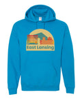 Image is a sapphire hooded sweatshirt with an image of various buildings within downtown East Lansing. Beneath the graphic, the text “East Lansing” is displayed.